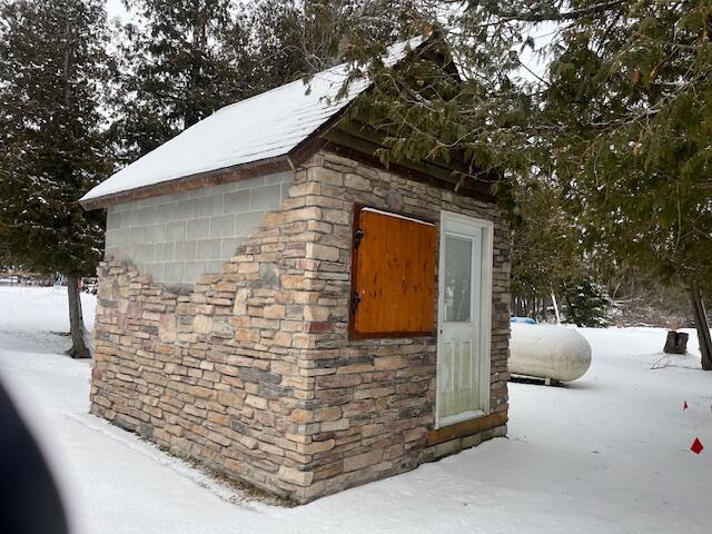 snow covered structure featuring an outbuilding