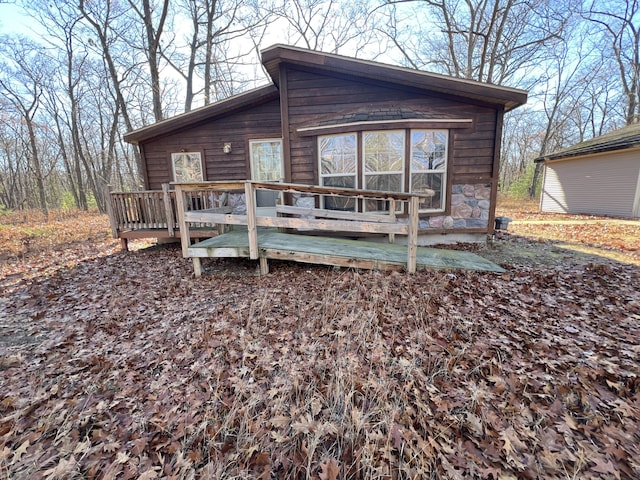 view of front of home featuring stone siding and a deck