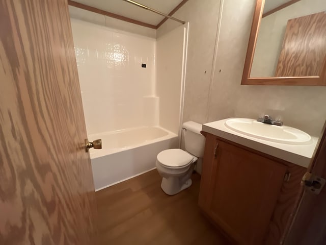 bathroom featuring vanity, toilet, wood finished floors, and shower / bathtub combination