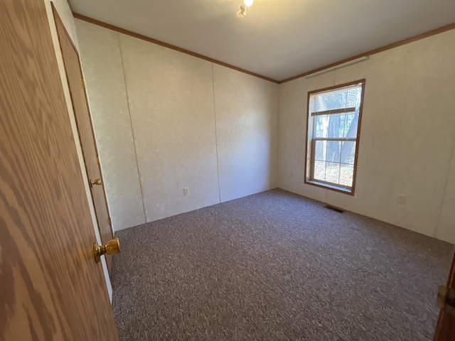 unfurnished room featuring crown molding, carpet flooring, and visible vents