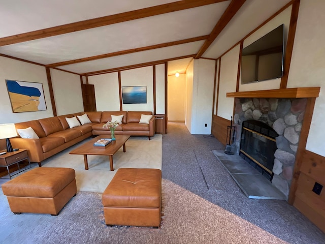 carpeted living area with a fireplace and vaulted ceiling with beams