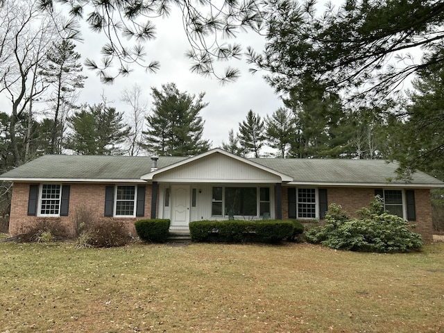 ranch-style house with a front lawn and brick siding