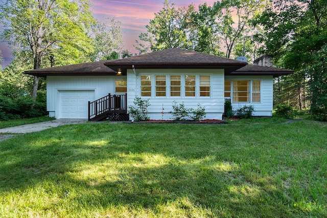 view of front of house featuring a front lawn, a garage, driveway, and a chimney