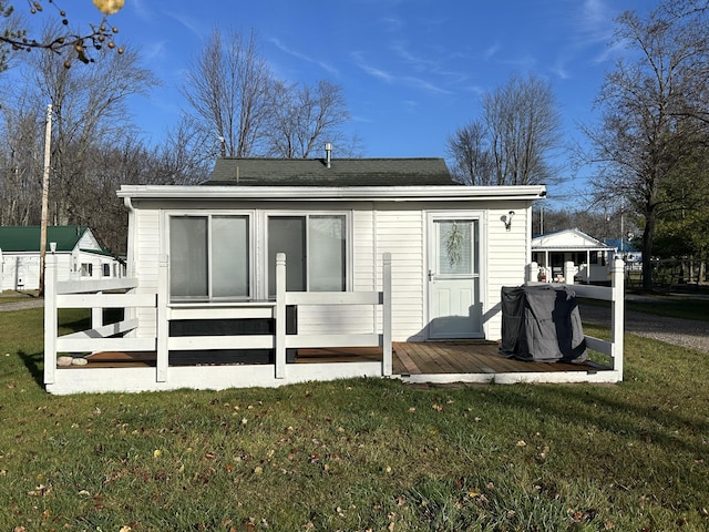 back of house with a lawn and a deck