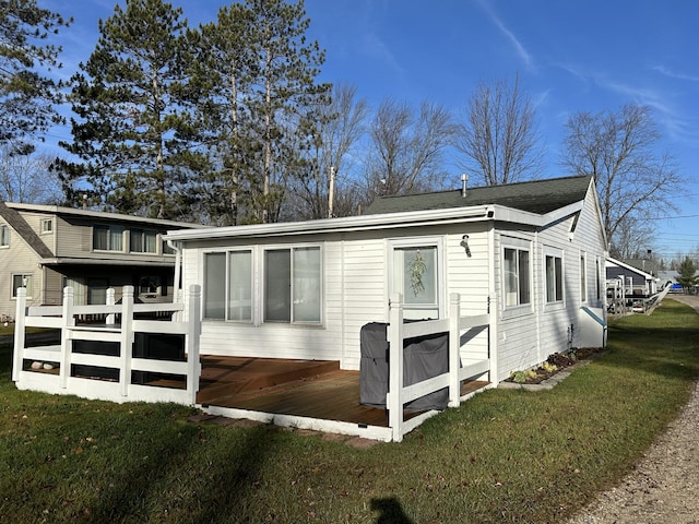 view of side of property featuring a lawn and a wooden deck