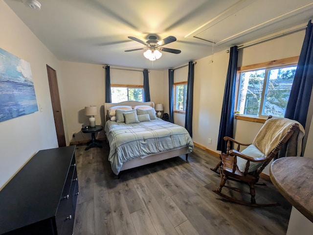 bedroom with ceiling fan, attic access, baseboards, and wood finished floors