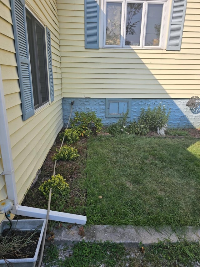 view of side of property with a lawn and crawl space