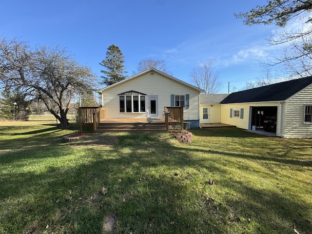 rear view of house with a lawn and a deck