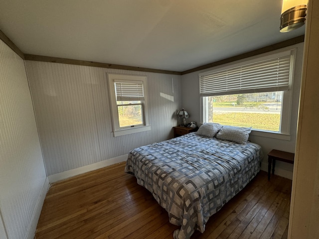 bedroom featuring baseboards, multiple windows, and hardwood / wood-style floors