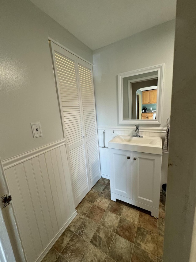 bathroom with a wainscoted wall and vanity