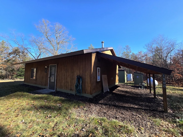 view of side of home featuring a carport and a yard