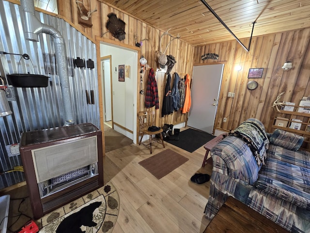 living area with hardwood / wood-style floors, heating unit, wood ceiling, and wood walls