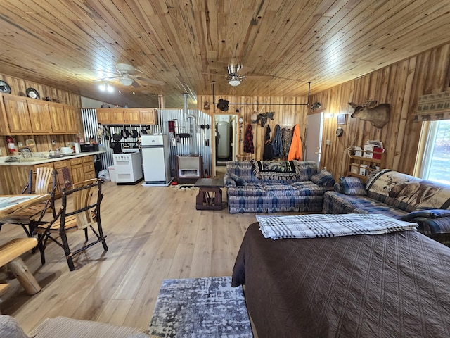 living room featuring light wood finished floors, wooden walls, wood ceiling, and a ceiling fan