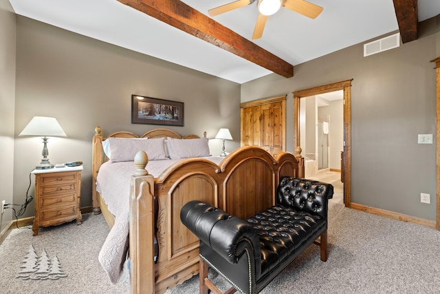 bedroom with visible vents, light carpet, beamed ceiling, connected bathroom, and baseboards