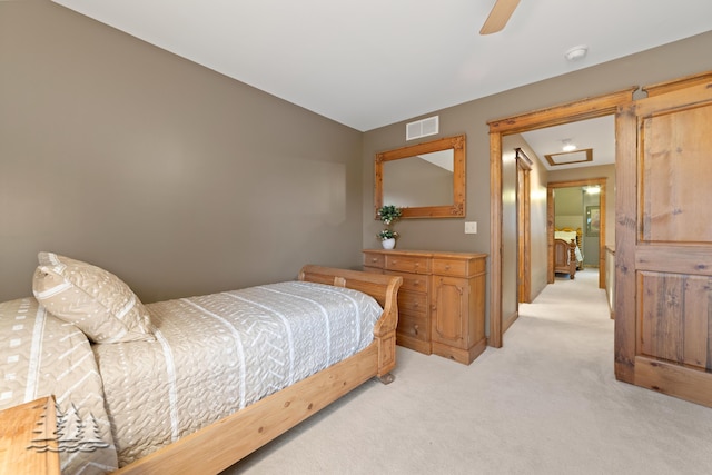 bedroom featuring visible vents, light colored carpet, attic access, and ceiling fan