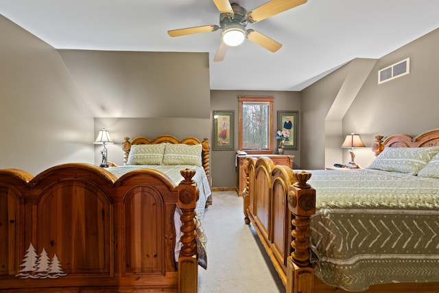 bedroom with vaulted ceiling, light colored carpet, visible vents, and ceiling fan