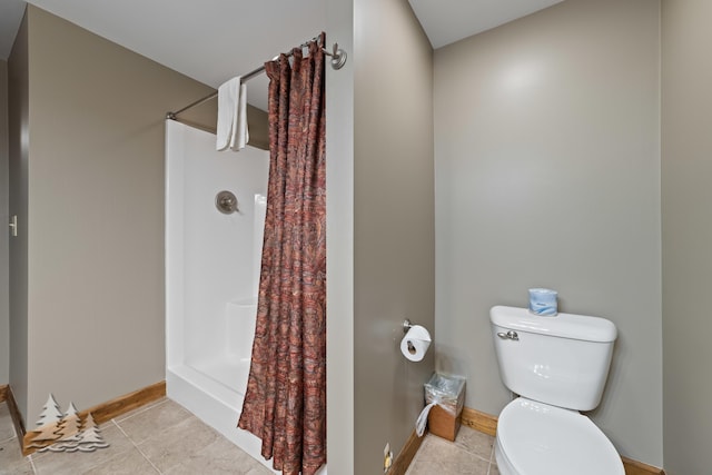 full bathroom featuring a shower with shower curtain, baseboards, toilet, and tile patterned floors