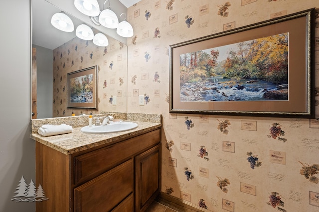 bathroom featuring wallpapered walls, vanity, and baseboards