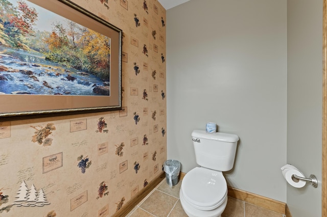 bathroom with tile patterned floors, wallpapered walls, toilet, and baseboards