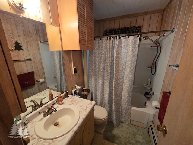 bathroom with vanity, wooden walls, toilet, and shower / bath combo