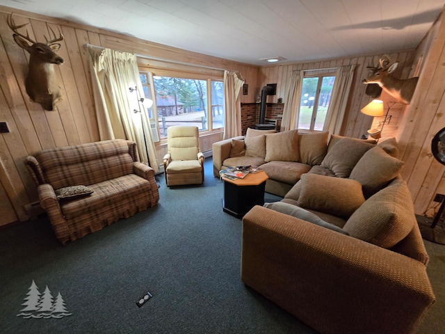 living area featuring a wood stove, plenty of natural light, wood walls, and carpet floors