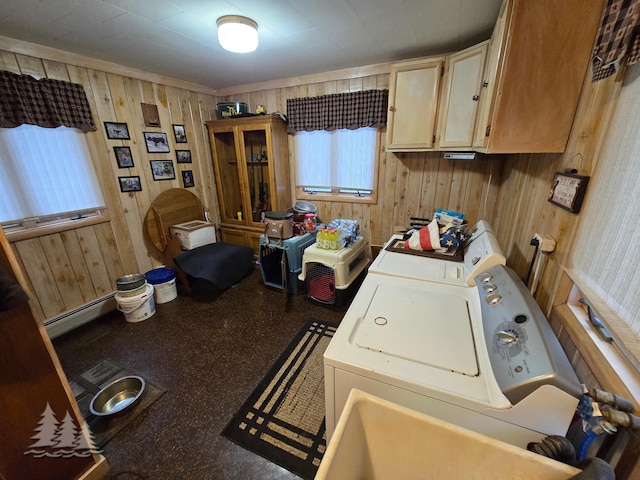 clothes washing area featuring washer and dryer, a baseboard radiator, cabinet space, and wooden walls