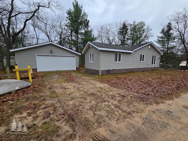 view of side of home with a garage, an outbuilding, and fence