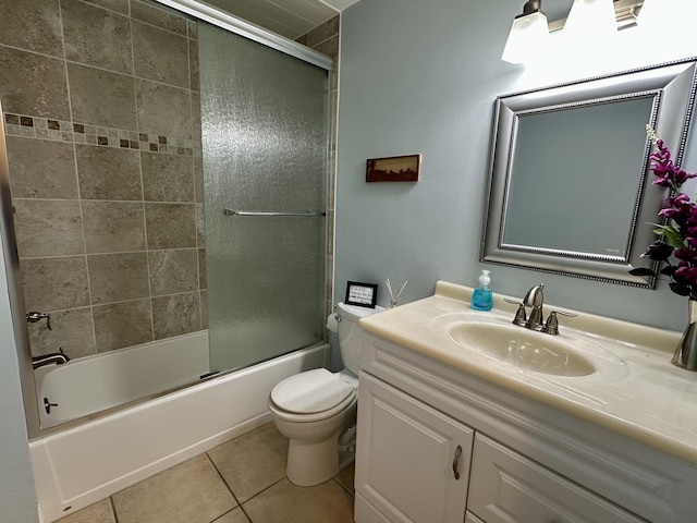 bathroom featuring shower / bath combination with glass door, toilet, vanity, and tile patterned flooring