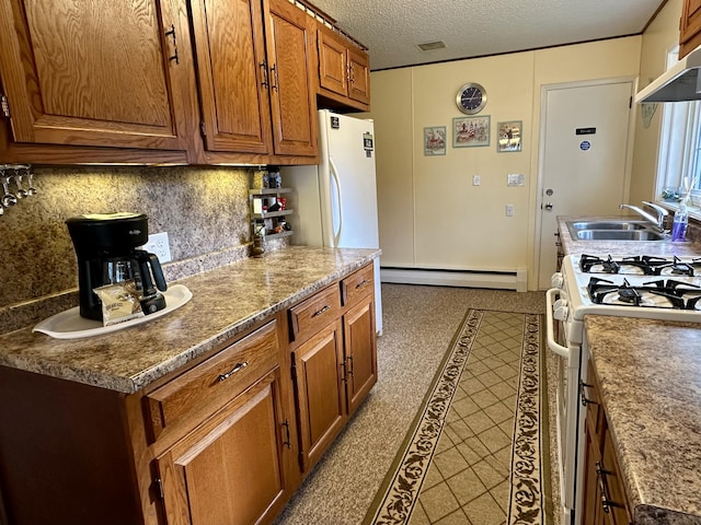 kitchen featuring gas range gas stove, a textured ceiling, a baseboard heating unit, brown cabinets, and backsplash
