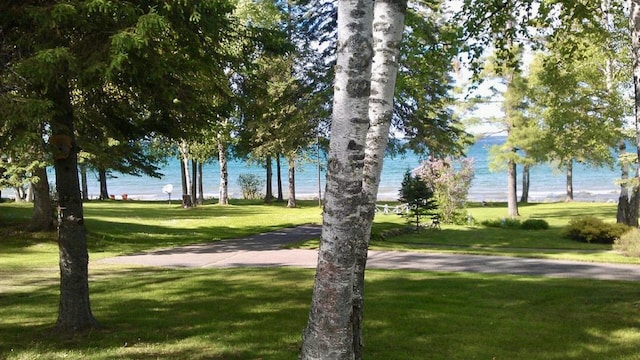 view of community with a lawn and a water view