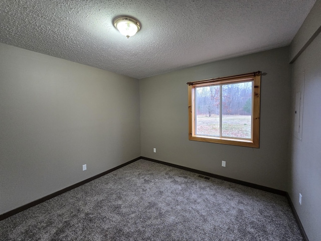 empty room featuring visible vents, baseboards, carpet, and a textured ceiling