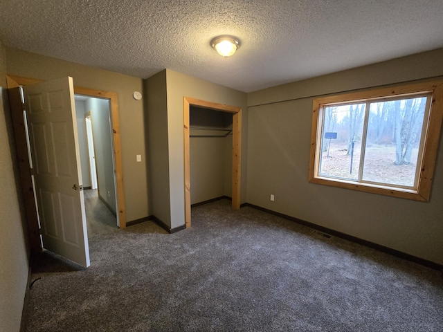 unfurnished bedroom featuring visible vents, baseboards, carpet, a closet, and a textured ceiling