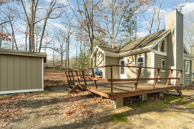 view of property exterior featuring a wooden deck, an outbuilding, and a chimney