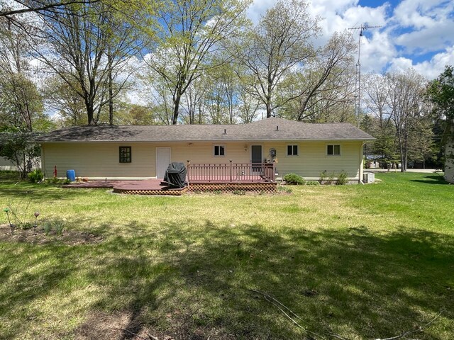 991 W Higgins Lake Dr, Roscommon, MI 48653 - back of property with a deck and a yard