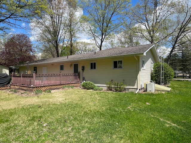 991 W Higgins Lake Dr, Roscommon, MI 48653 - back of house with a deck, a lawn, and a shingled roof