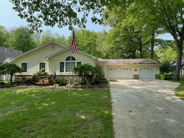 991 W Higgins Lake Dr, Roscommon, MI 48653 - ranch-style house featuring an attached garage, driveway, and a front yard