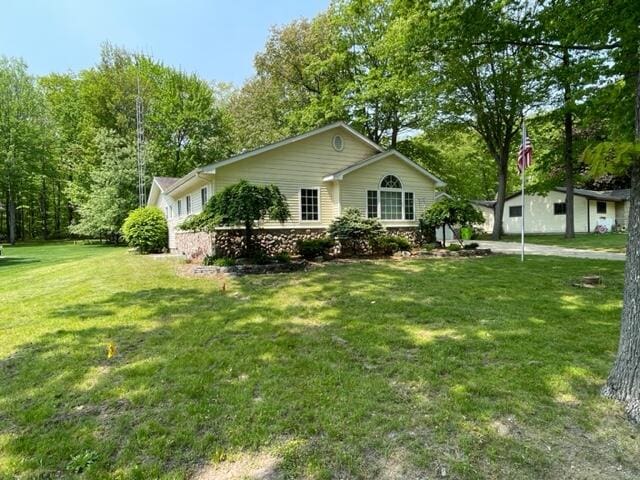 991 W Higgins Lake Dr, Roscommon, MI 48653 - ranch-style house featuring a front lawn