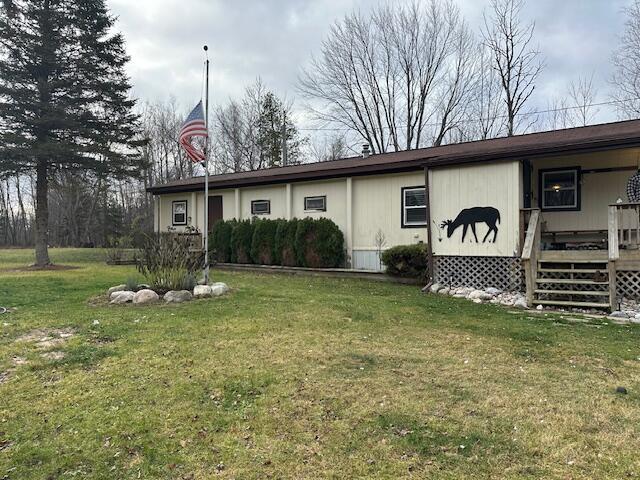 view of front of home with a wooden deck and a front yard