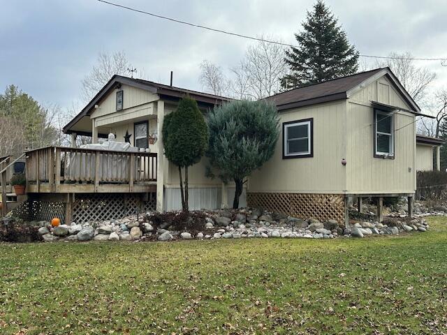 exterior space with a wooden deck and a front lawn