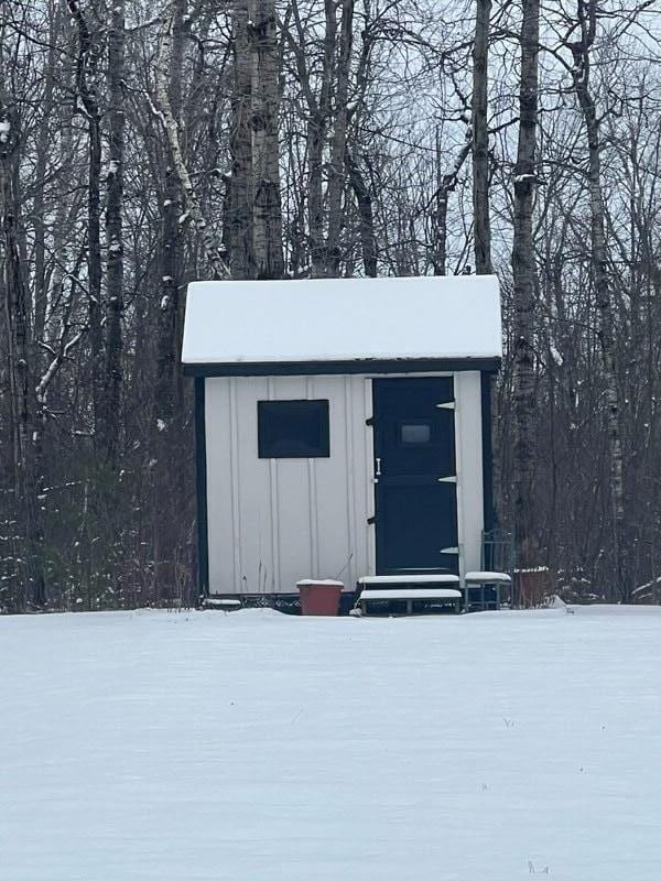 snow covered structure with an outdoor structure