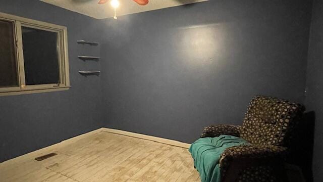 bedroom with baseboards, wood finished floors, visible vents, and ceiling fan