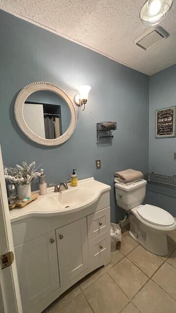 bathroom with visible vents, toilet, vanity, and tile patterned flooring