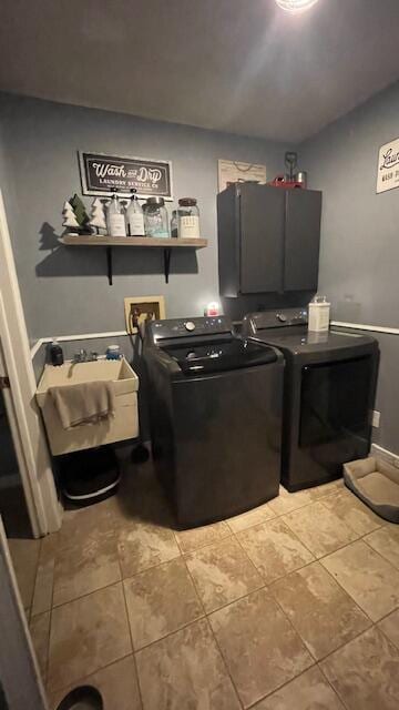 laundry area featuring washing machine and clothes dryer, light tile patterned floors, cabinet space, and a sink