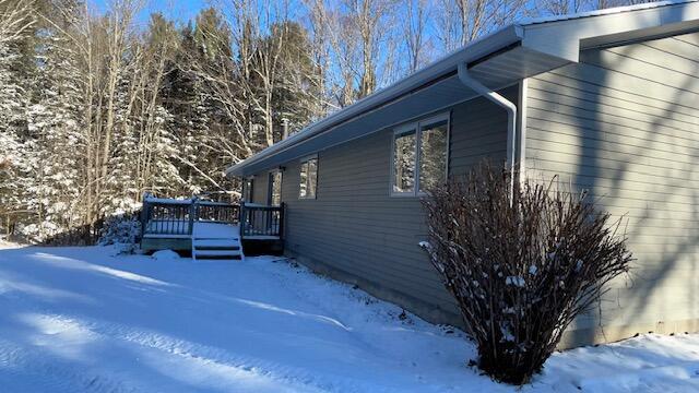 view of snow covered exterior with a deck