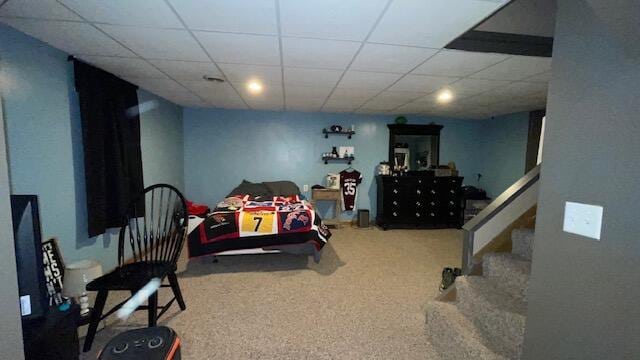 bedroom featuring carpet flooring and a drop ceiling