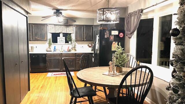 kitchen featuring black appliances, light wood-style flooring, light countertops, and dark brown cabinetry