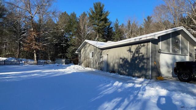 snow covered property featuring an attached garage