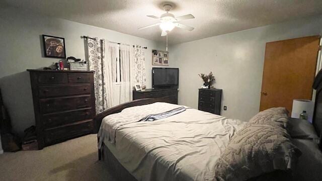 bedroom with a ceiling fan, carpet flooring, and a textured ceiling