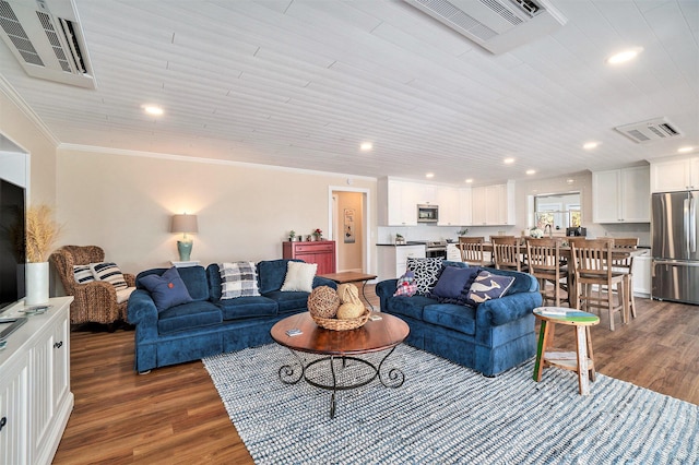 living area featuring visible vents, wood finished floors, and ornamental molding