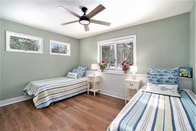 bedroom with multiple windows, ceiling fan, and wood finished floors